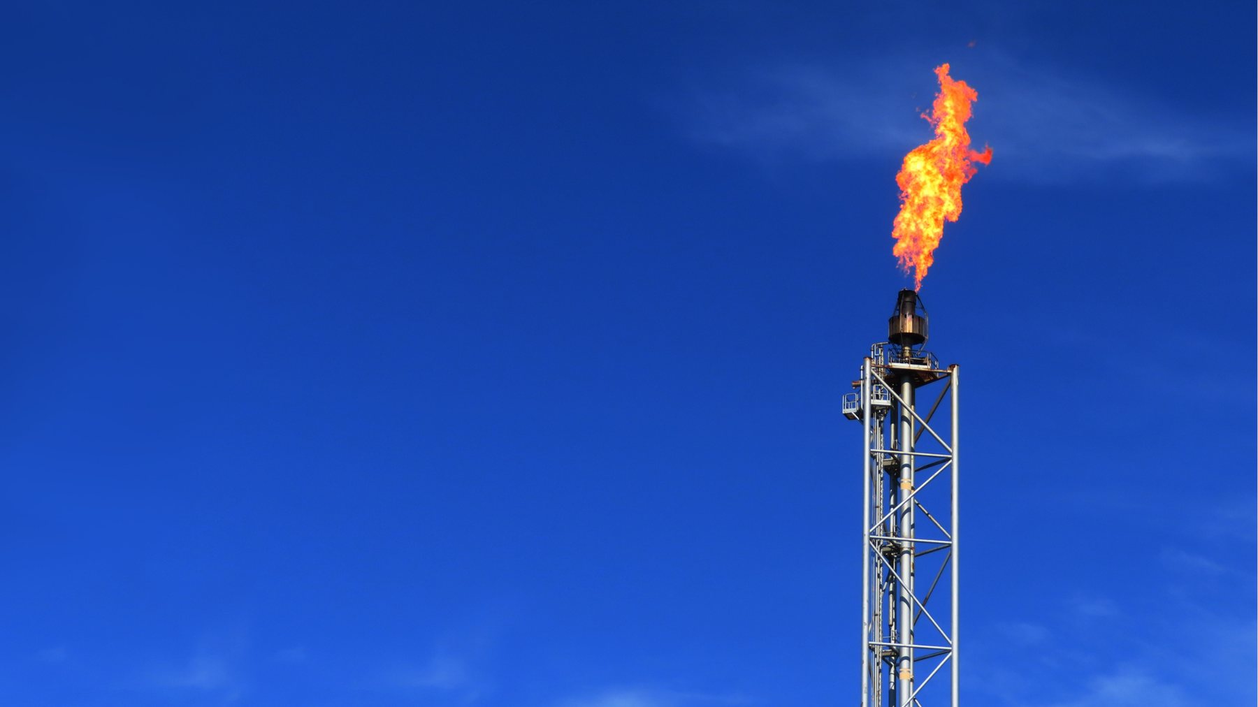 Tocha de flare gas em operação contra céu azul